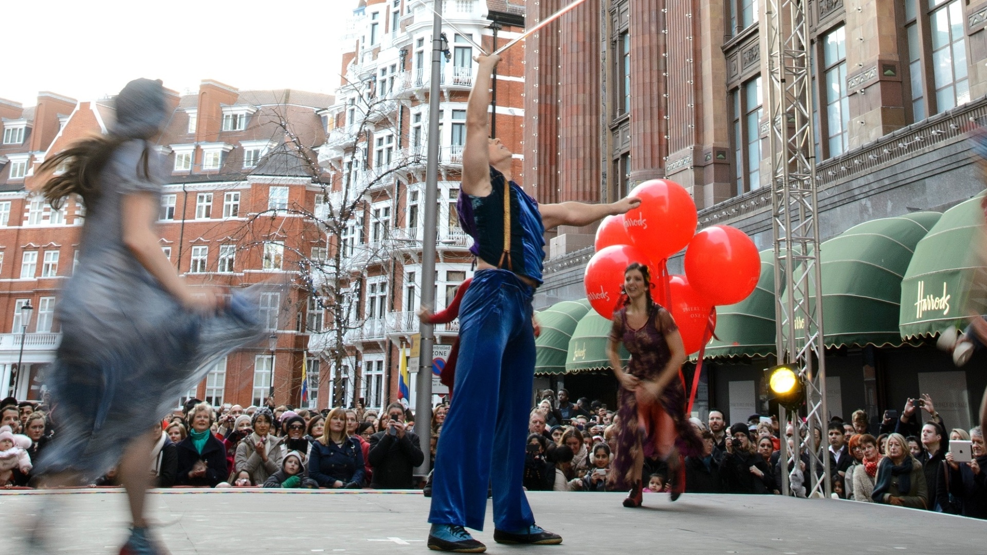 26.dez.2012 - Cirque Du Soleil faz uma performance especial para os visitantes que aguardam pela liquidação de inverno do lado de fora da loja Harrods, em Londres - Ben Pruchnie/Getty Images