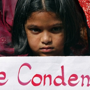 Menina segura um cartaz onde se lê "nós condenamos" durante protesto em Hyderabad, na Índia, pedindo mais segurança - Krishnendu Halder/Reuters