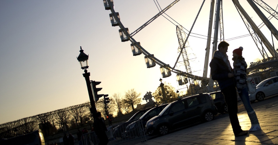 30.dez.2012 - Casal namora em frente a roda gigante na praça Concorde, em Paris, na França