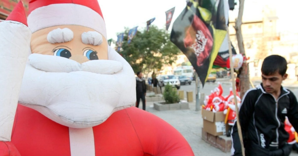30.dez.2012 - Homem passa ao lado de boneco inflável de Papai Noel em Bagdá, no Iraque