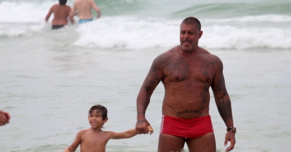 2.jan.2013 De sunga vermelha, Alexandre Frota curte praia na Barra da Tijuca ao lado do enteado Enzo