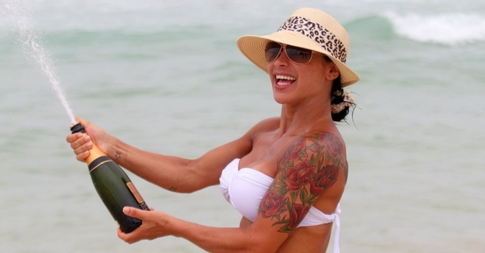 2.jan.2013 Fabiana Frota, mulher de Alexandre Frota, estoura champanhe durante dia de praia em família na Barra da Tijuca