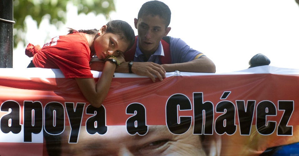 5.jan.2013 - Dupla se apóia em cartaz de apoio ao presidente da Venezuela, Hugo Chávez, em manifestação em frente à Assembleia Nacional, em Caracas