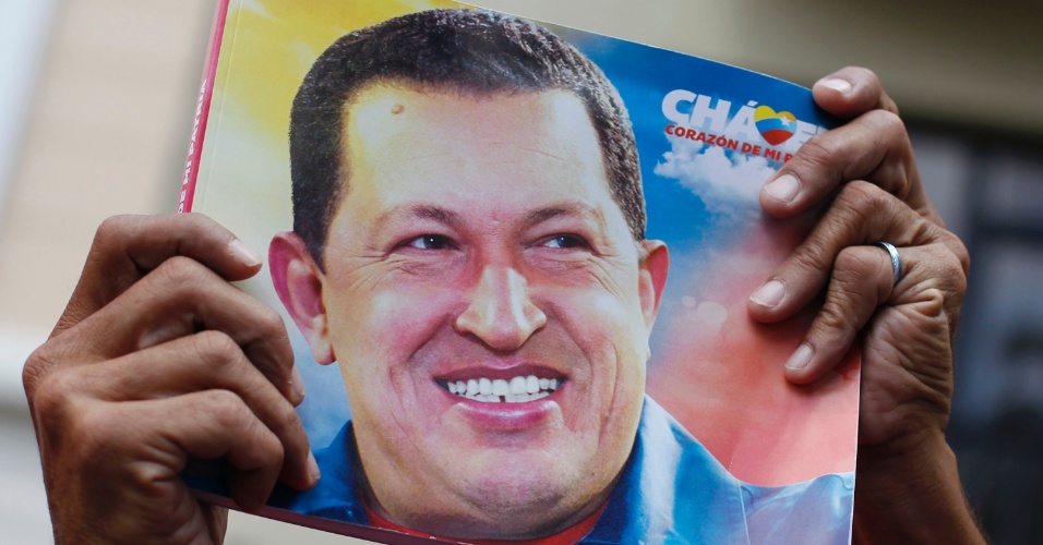 5.jan.2013 - Partidário de Hugo Chávez segura foto do presidente durante manifestação em frente à Assembleia Nacional, em Caracas