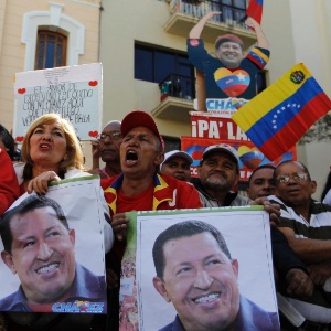 Partidários de Hugo Chávez levam cartazes com imagens do presidente em frente à Assembleia Nacional em Caracas