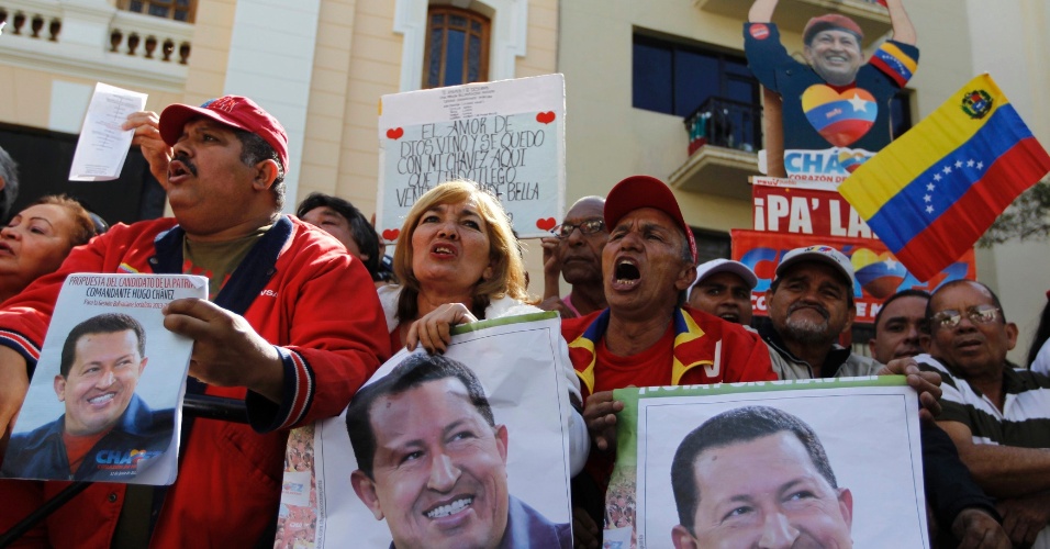 5.jan.2013 - Partidários de Hugo Chávez levam cartazes com imagens do presidente em frente à Assembleia Nacional em Caracas, na Venezuela