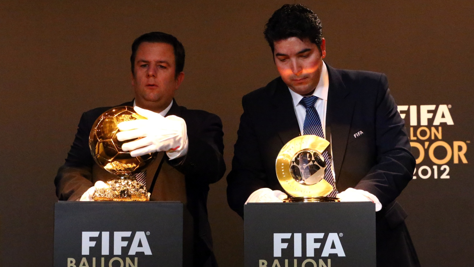07.jan.2013- Seguranças limpam troféus de melhor jogador e melhor jogadora do mundo em 2012 antes do evento de premiação da Fifa - Christof Koepsel/Getty Images
