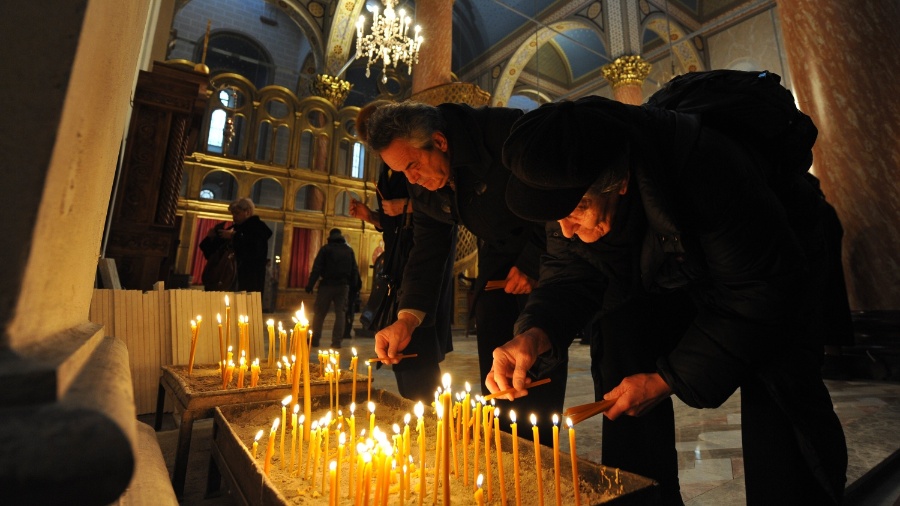 Cristãos ortodoxos acendem velas no Natal, celebrado em 7 de janeiro - Elvis Barukcic/AFP
