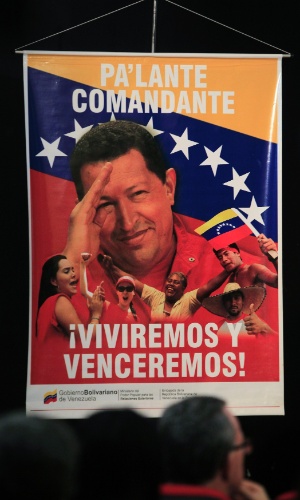 7.jan.2013 - Cartaz com foto do presidente da Venezuela Hugo Chávez é exibido durante uma conferência organizada pelo Ministério da Cultura de Cuba para desejar uma rápida recuperação para Chávez, em Havana, capital cubana, nesta segunda-feira (7). O cartaz diz: "Vá em frente comandante, vamos viver e vencer!". A incerteza sobre a presença do presidente Hugo Chávez - internado em Cuba após sua quarta cirurgia para combater um câncer - na cerimônia de posse para o seu novo mandato, dia 10 de janeiro, tem gerado a possibilidade de que a Venezuela tenha que definir na Justiça sobre quem tem o direito de chefiar o governo