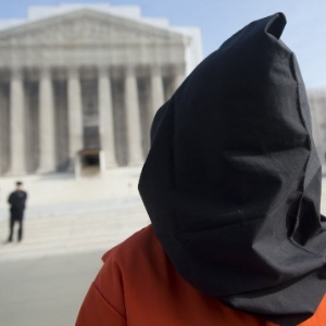 8.jan.2013 -  Com uniforme de presidiário e rosto coberto, manifestante protesta em frente à Suprema Corte norte-americana, em Washington (EUA),  contra a manutenção da  prisão militar de Guantánamo - Saul Loeb/AFP