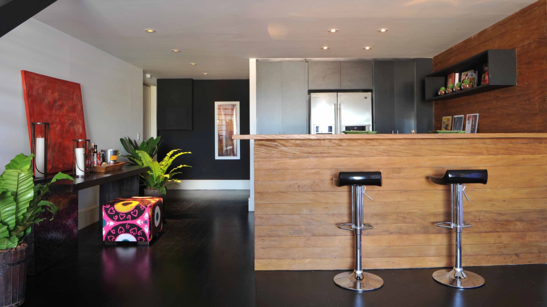 A arquiteta Deborah Roig recorreu à madeira de demolição para delimitar a área da cozinha (8m²) deste loft de 150 m². Repare que para manter a unidade dos ambientes sociais ela usou o mesmo piso ebanizado. Em uma das paredes, o projeto previu a instalação do armário que embute a geladeira. Nas outras duas superfícies, a profissional distribuiu os eletrodomésticos e cuba com bancada de trabalho - Eduardo Girão/ Divulgação