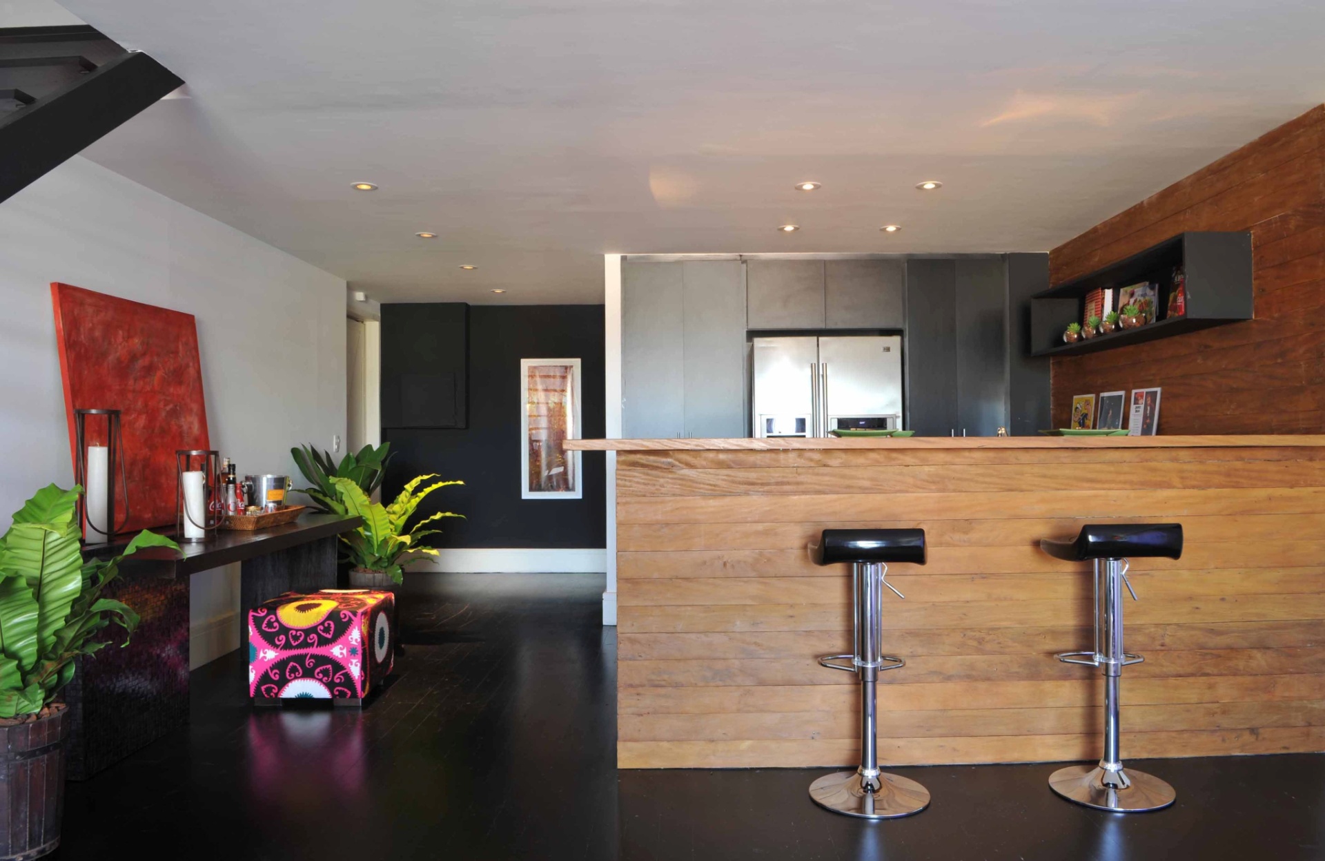 A arquiteta Deborah Roig recorreu à madeira de demolição para delimitar a área da cozinha (8m²) deste loft de 150 m². Repare que para manter a unidade dos ambientes sociais ela usou o mesmo piso ebanizado. Em uma das paredes, o projeto previu a instalação do armário que embute a geladeira. Nas outras duas superfícies, a profissional distribuiu os eletrodomésticos e cuba com bancada de trabalho - Eduardo Girão/ Divulgação