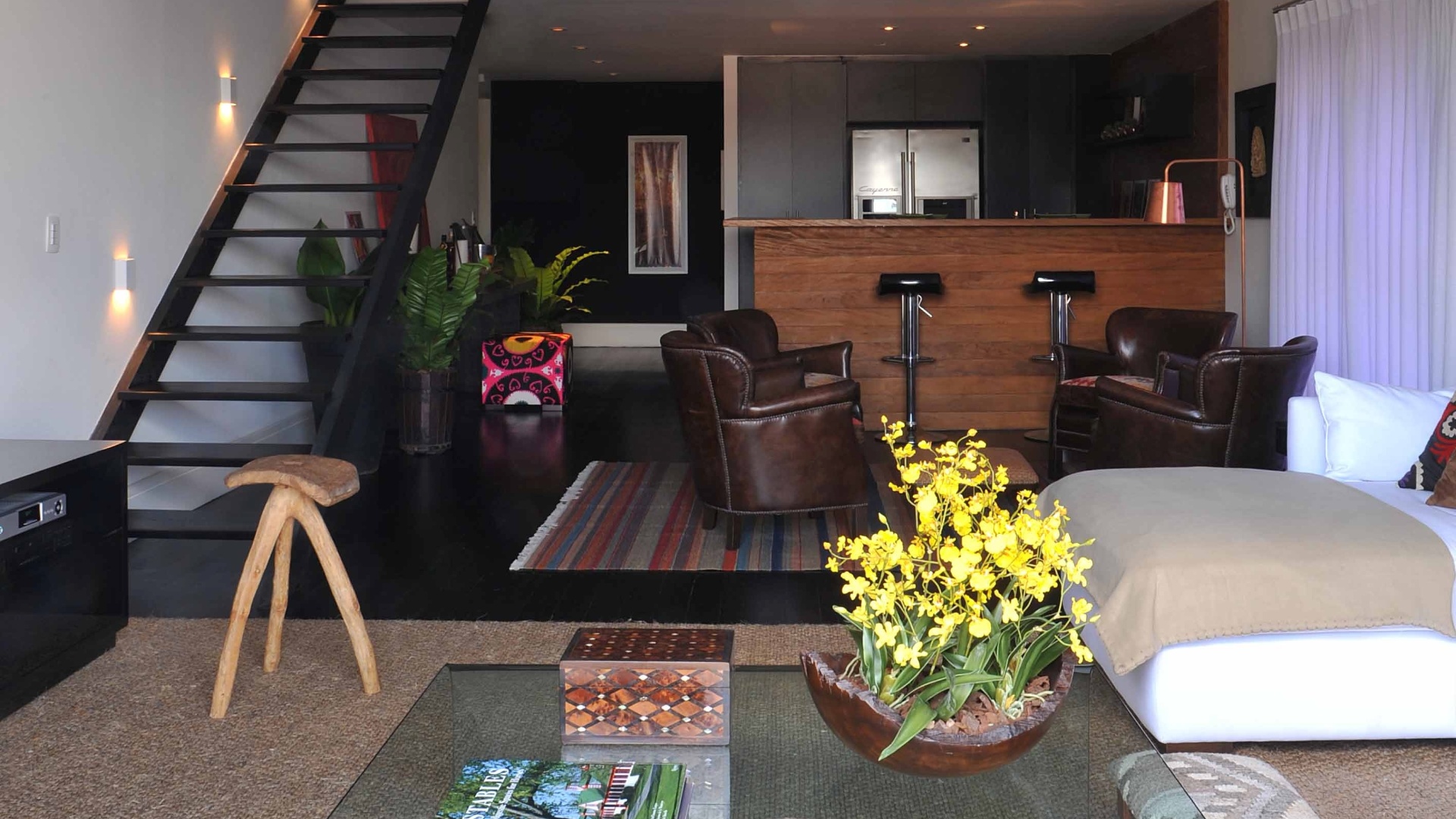 A arquiteta Deborah Roig recorreu à madeira de demolição para delimitar a área da cozinha (8m²) deste loft de 150 m². Repare que para manter a unidade dos ambientes sociais ela usou um mesmo piso ebanizado. Em uma das paredes, o projeto previu a instalação do armário que embute a geladeira. Nas outras duas superfícies, a profissional distribuiu os eletrodomésticos e a cuba com bancada de trabalho - Eduardo Girão/ Divulgação