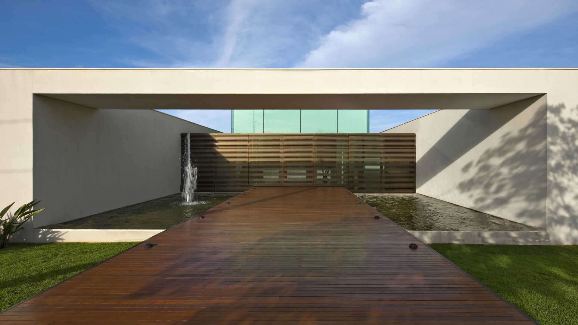 No acesso à casa projetada pelo arquiteto mineiro Gustavo Penna, o deck cruza o espelho d'água como uma ponte - Jomar Bragança/Divulgação