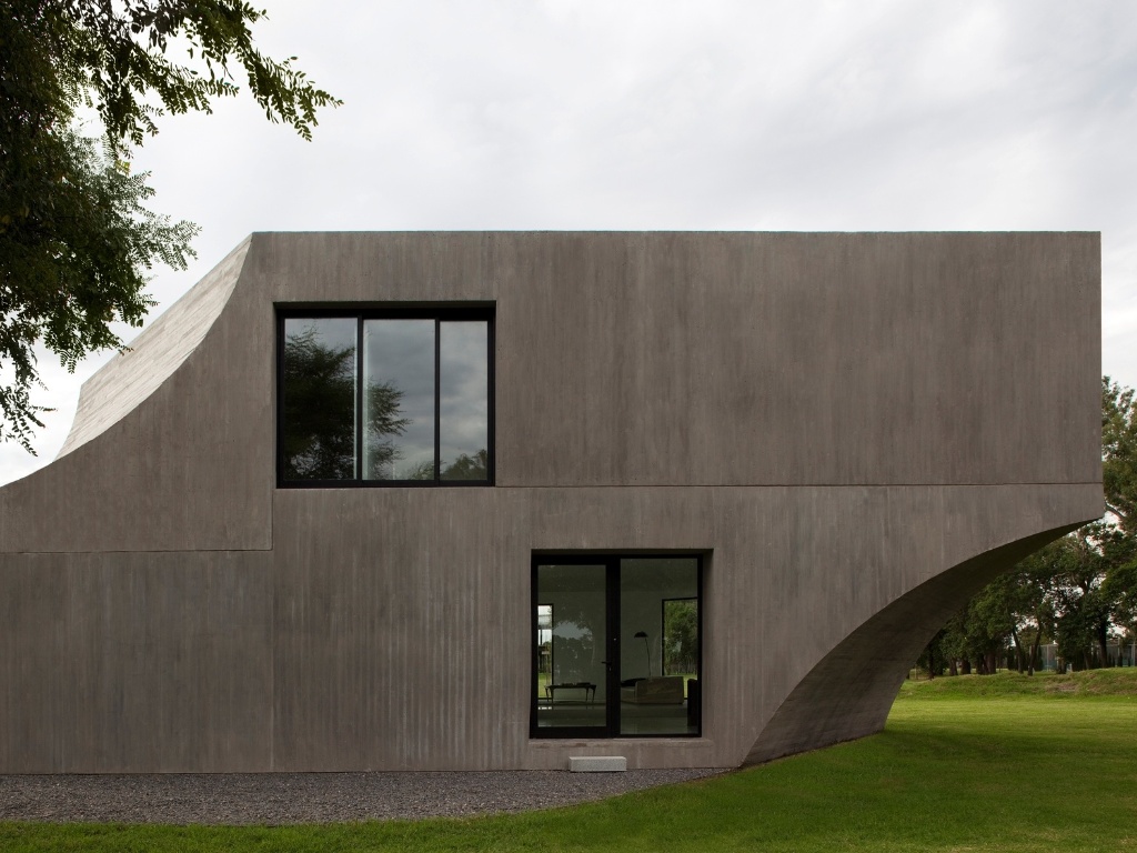 A fachada sul da View House, totalmente em placas de concreto pré-moldado, é uma superfície plana de onde partem incisões curvas laterais. Esses eixos apontam para os dois caixilhos que, além de garantir a composição da fachada de maneira equilibrada, oferecem luz e ventilação naturais tanto ao pavimento térreo, quanto ao superior. A arquitetura da View House é assinada por Diego Arraigada, Mark Lee e Sharon Johnston - Leonardo Finotti/ UOL