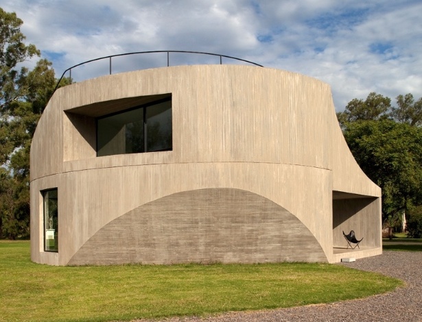 Para o norte, a fachada assume uma dinâmica rotacional pura: esta é a principal face da edificação a receber luz solar, assim a inserção da janela superior no monolito de concreto, em ângulo, garante que o interior do pavimento receba maior quantidade de luz pela manhã, quando o sol é mais ameno. A View House, na Argentina, foi projetada por Diego Arraigada, Mark Lee e Sharon Johnston - Leonardo Finotti/ UOL