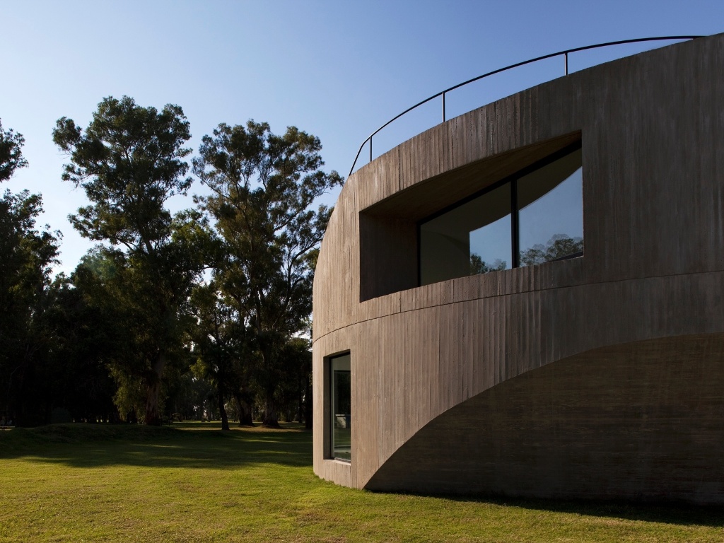 Para o norte, a fachada assume uma dinâmica rotacional pura: esta é a principal face da edificação a receber luz solar, assim a inserção da janela superior no monolito de concreto, em ângulo, garante que o interior do pavimento receba maior quantidade de luz pela manhã, quando o sol é mais ameno. A View House, na Argentina, foi projetada por Diego Arraigada, Mark Lee e Sharon Johnston - Leonardo Finotti/ UOL