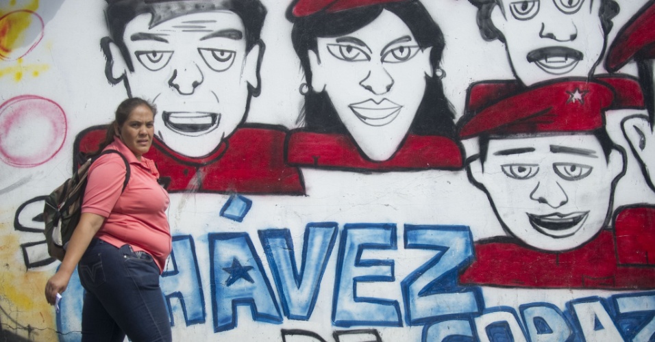 9.jan.2013 - Mulher passa por muro com pichação com frase de apoio ao presidente venezuelano Hugo Chávez, nesta quarta-feira (9). O Supremo Tribunal da Venezuela confirmou o adiamento indefinido da tomada de posse de Chávez para um novo mandato e disse que sua administração atual pode continuar no cargo nesse ínterim. Chávez, que sofreu sua quarta cirurgia de câncer em Havana há quase um mês, está sofrendo de uma grave infecção pulmonar, que resultou em uma insuficiência respiratória