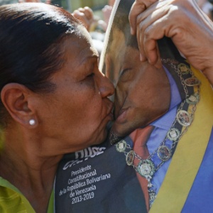 Venezuelana beija imagem de Chávez na quinta (10) - Leo Ramirez/AFP
