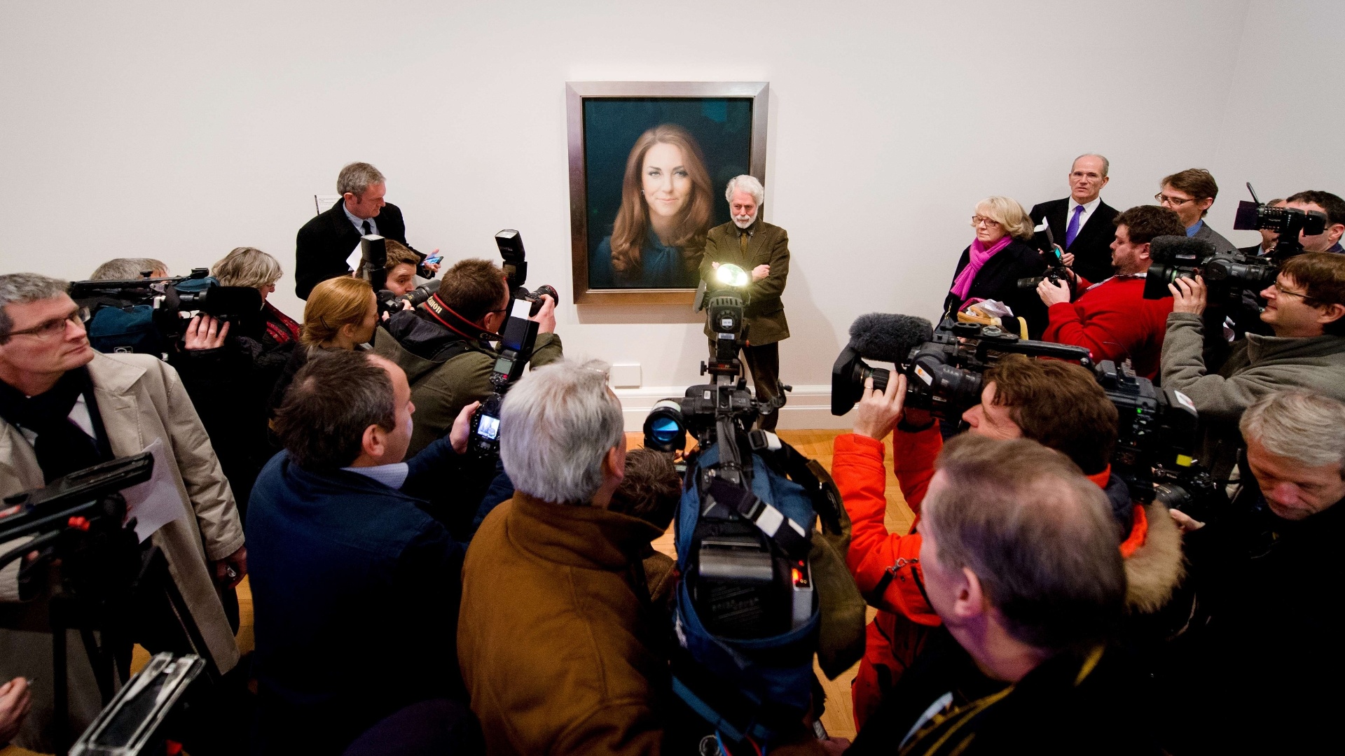 11.jan.2013 - O artista Paul Emsley posa ao lado do retrato oficial de Kate Middleton - AFP