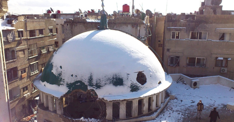 13.jan.2013 - Mesquista danificada por bombardeios de tropas sírias é coberta pela neve na cidade de Daraya, perto de Damasco