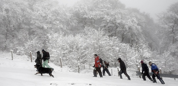 Um grupo de pessoas sobe a montanha de Ibañeta, em Navarra, na Espanha, em meio à paisagem coberta de neve - Jesús Diges/EFE