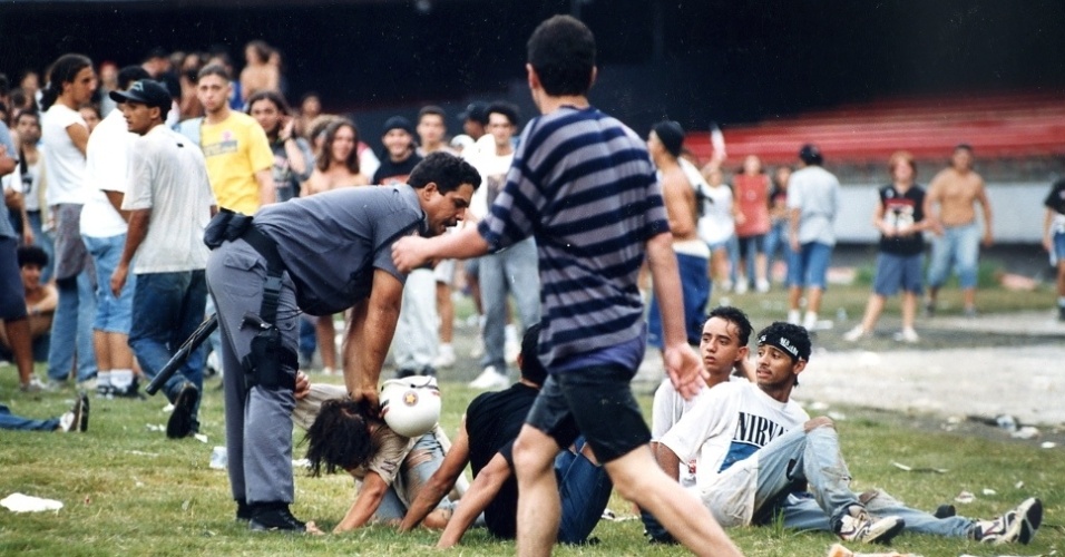 16 jan. 1993 - Após jogar água em diversas garotas, rapaz é forçado por policial a ficar no chão, durante o segundo dia do Hollywood Rock. - Pisco Del Gaiso/Folhapres