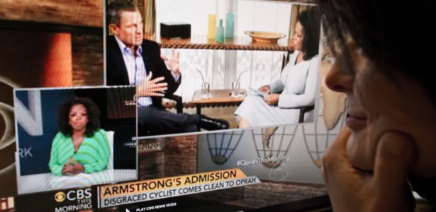 Mulher assiste ao This Morning, em que Oprah Winfrey revela detalhes da entrevista que fez com Armstrong - AFP PHOTO/MLADEN ANTONOV