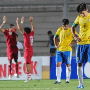 18.jan.2013 - Peruanos comemoram enquanto brasileiros ficam de cabeça baixa. Brasil perdeu por 2 a 0 e foi eliminado do Sul-Americano sub-20 - AP Photo/Marcos Garcia