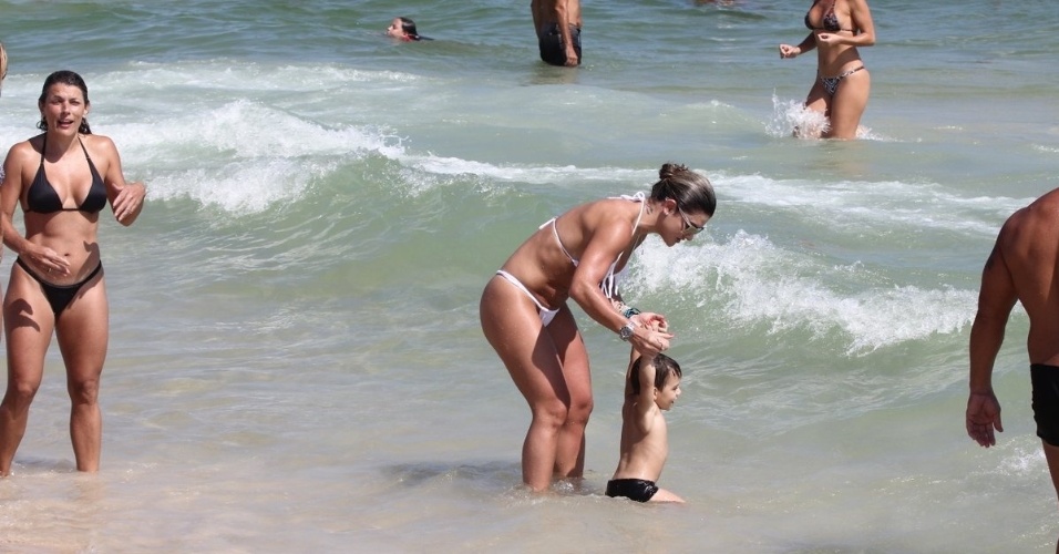 19.jan.2013 -  Mirella Santos brinca com criança na Praia do Pepe, Barra da Tijuca