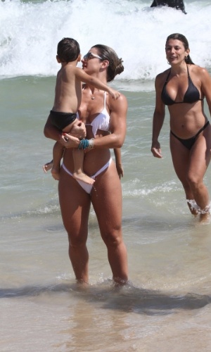 19.jan.2013 -  Mirella Santos brinca com menino na Praia do Pepe, Barra da Tijuca