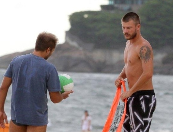 20.jan.2013 - Rodrigo Hilbert arruma rede em praia para jogar futevôlei do Rio 