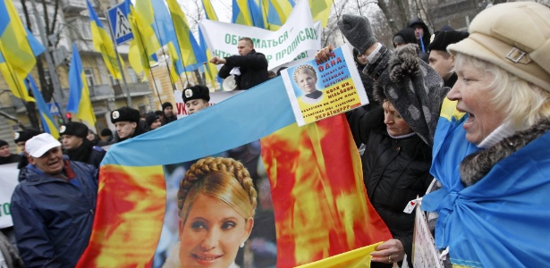 Opositores ucranianos levantam imagens da líder da oposição Yulia Tymoshenko durante uma manifestação perto da sede da presidência, em Kiev, capital da Ucrânia