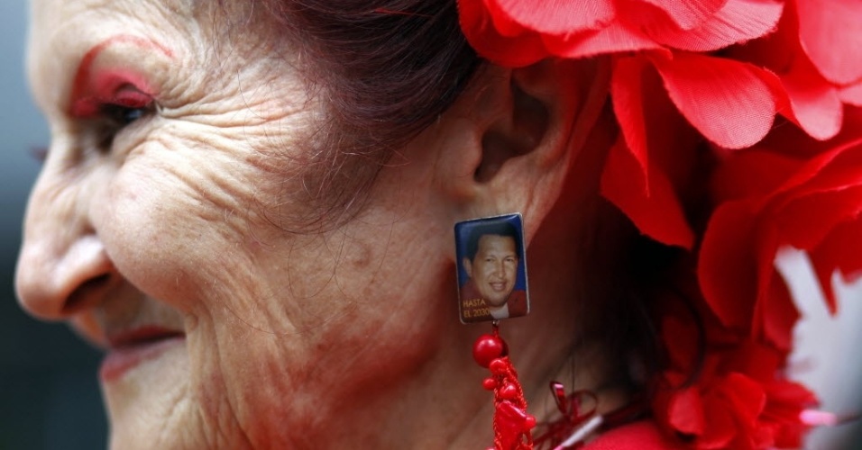 23.jan.2013 - Apoiador de Hugo Chávez usa brincos com foto do do presidente venezuelano durante uma marcha em Caracas, na Venezuela, para celebrar 55 anos de democracia no país, com a queda da ditadura de Marcos Pérez Jiménez (1952-1958). Os manifestantes também homenageam Chávez, líder da Revolução Bolivariana, que se recupera de uma operação contra um câncer realizada em Cuba há um mês e meio