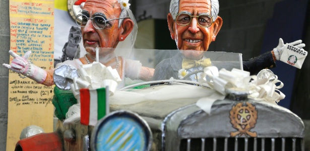 Carro decorado com bonecos do presidente italiano, Giorgio Napolitano, e do primeiro-ministro, Mario Monti, com um bilhete pregado na mão onde se lê "recém-casados" - Fabio Muzzi/AFP