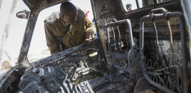 26.jan.2013 - Soldado malinês observa destroços de caminhão destruído de rebeldes islâmicos em Konna, cidade-chave controlada agora por franceses e pelo Exército do Mali - Fred Dufour/AFP