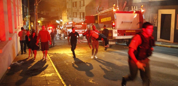 Ezequiel Corte Real (ao centro) carrega corpo de vítima no incêndio da boate Kiss, no domingo (27) - Germano Roratto/Agência RBS