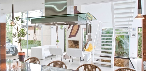 No projeto de Flavio Castro, paredes inteiramente envidraçadas banham sala e cozinha integradas de luz - Divulgação