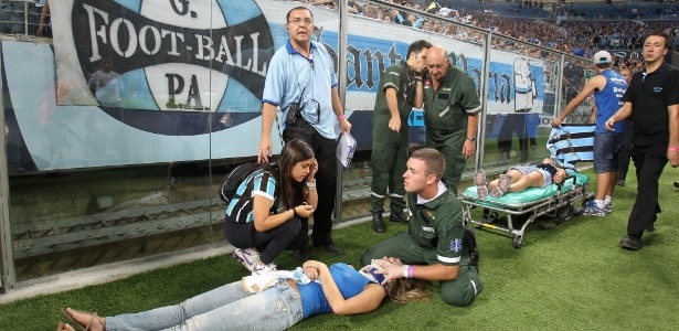 Torcedora é atendida pelos médicos após queda no jogo entre Grêmio e LDU  - AP Photo/Nabor Goulart