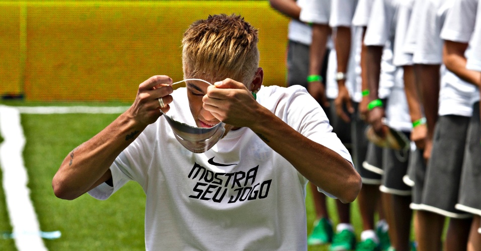 31.jan.2013 - Neymar coloca máscara de si mesmo durante apresentação do uniforme que será usado pela seleção brasileira na Copa das Confederações