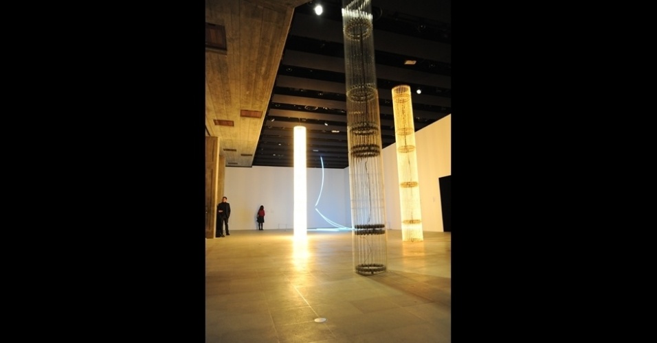 A instalação "S=U=P=E=R=E=S=T=R=U=T=U=R=A" tem uma presença dominadora. As colunas feitas de faixas incandescentes obsoletas se acendem e diminuem a intensidade gerando calor intermitente. O autor, Cerith Wyn Evans, diz que "por causa do modo como são feitas para se comportarem, elas são relativamente invisíveis". "Elas estão em suspensão entre o céu e a terra", acrescenta - Emma Lynch/BBC