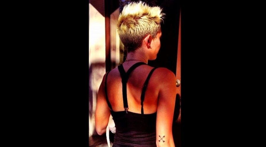 1.fev.2013 - Miley Cyrus exibiu a nova tatuagem: duas pequenas setas cruzadas no braço direito. O desenho foi feito por Kat Von D