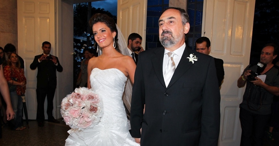 2.fev.2013 - A noiva Gabriela Pauletti entra na igreja Santo Ivo com seu pai. A capela fica na região do parque do Ibirapuera, em São Paulo