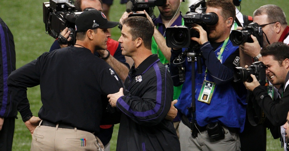 03.fev.2013 - Irmãos Jim (e) e John Harbaugh, técnicos de 49ers e Ravens, se abraçam no aquecimento para o Super Bowl