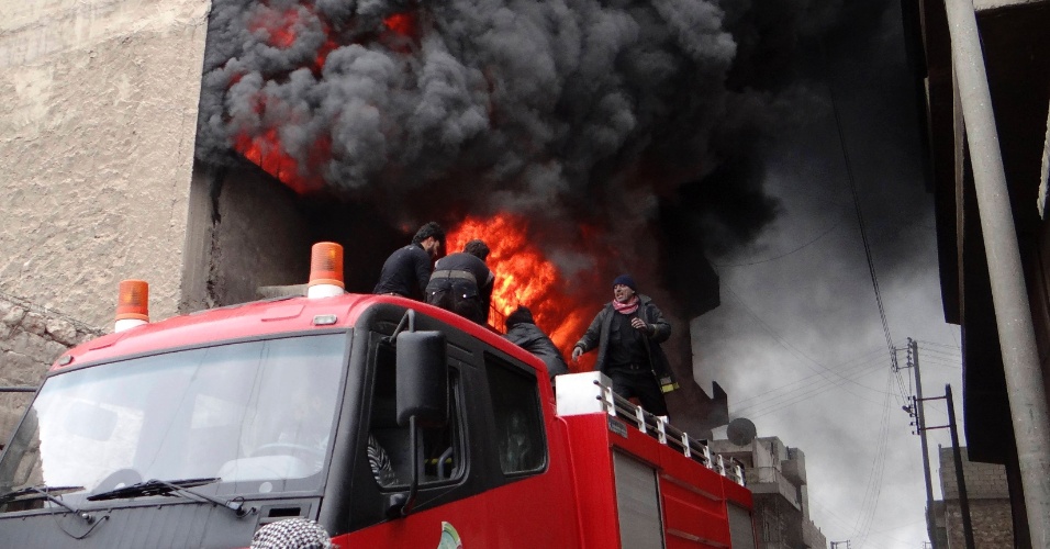 8.fev.2013 - Bombeiros tentam apagar incêndio em fábrica próxima a Aleppo, na Síria, após suposto bombardeio comandado por forças leais ao presidente Bashar al-Assad, nesta sexta-feira (8)