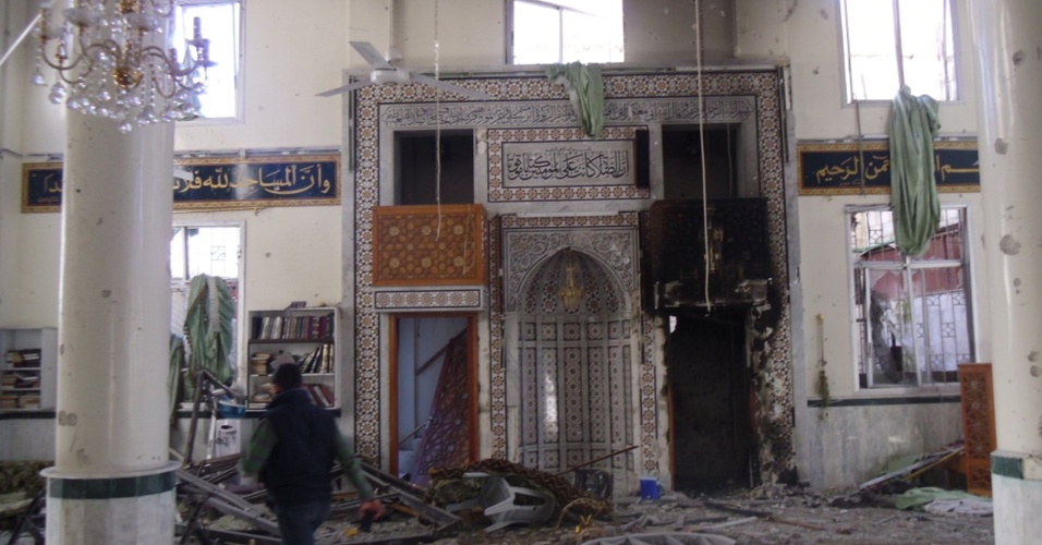 8.fev.2013 - Homem inspeciona uma mesquita destruída no subúrbio de Damasco, na Síria