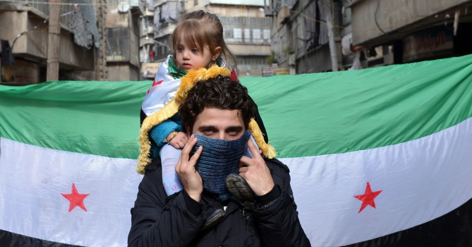 8.fev.2013 - Manifestante antirregime sírio carrega criança nos ombros durante protesto no distrito de Bustan al-Qasr, ao norte da cidade de Aleppo, na Síria, nesta sexta-feira (8)
