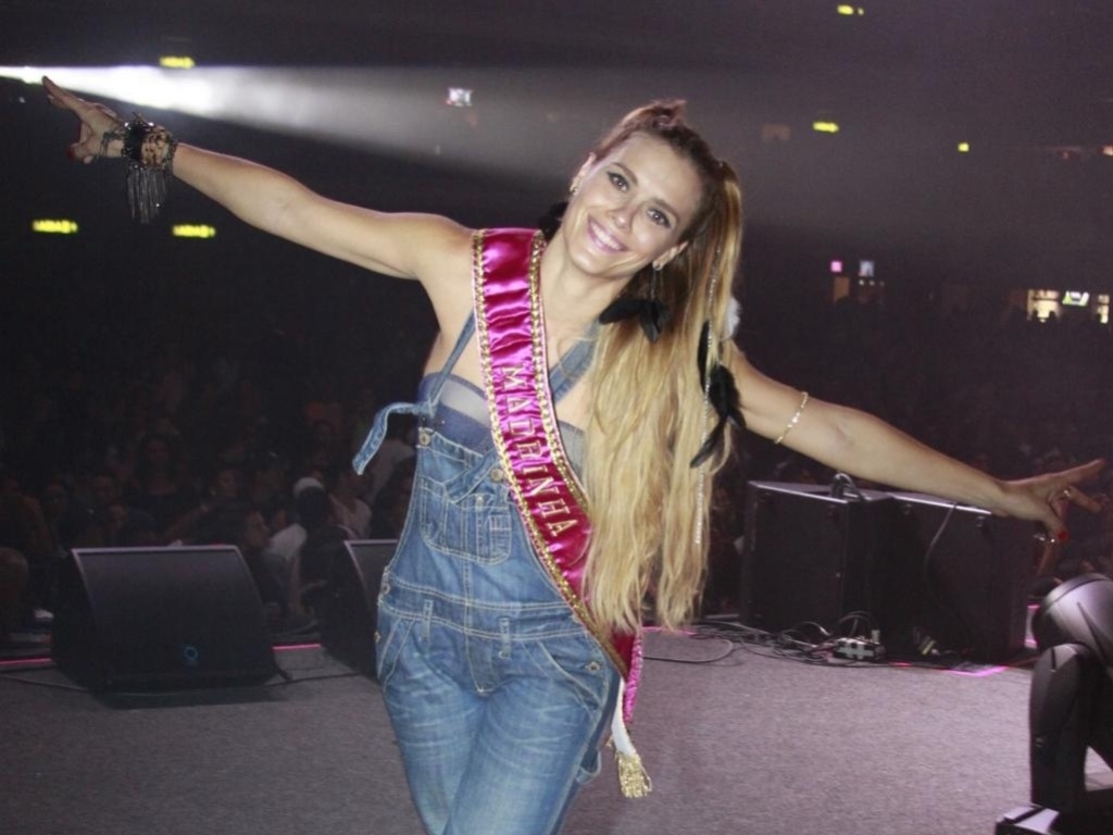 Carolina Dieckmann não deixou o conforto de lado para o ensaio da Grande Rio e apostou na combinação de macacão jeans com tênis - Agnews