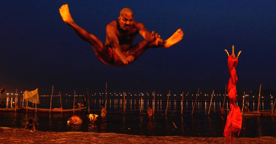 12.fev.2013 - Devoto salta antes banho sagrado nas margens do rio Ganges, na Índia