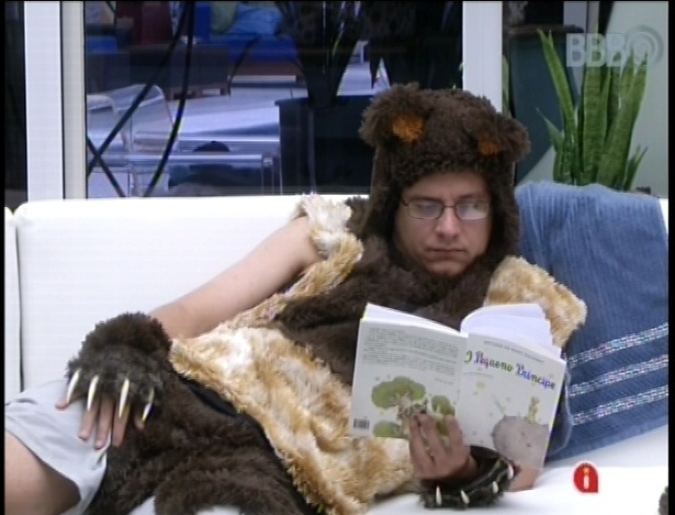 16.fev.2013 - Vestido de ursinho, cumprindo o castigo do anjo, e sem poder nadar na piscina, Ivan lê o livro 